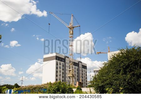 house under construction with a crane on blue sky background