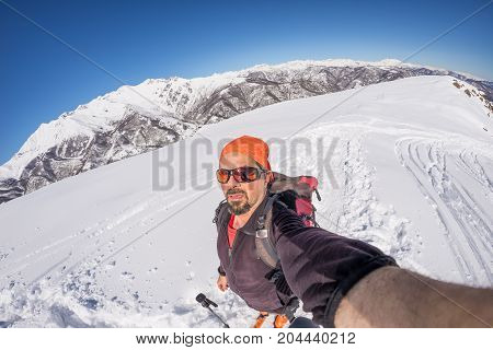 Adult Alpin Skier With Beard, Sunglasses And Hat, Taking Selfie On Snowy Slope In The Beautiful Ital