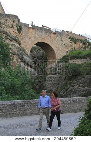 Ronda, Spain - May 2, 2014: Tourist couple walking near Puente Nueve Bridge in Ronda, Spain