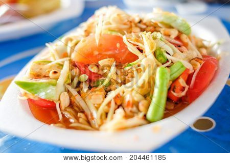 Som Tum Thai or Green Papaya Salad serve on styrofoam plate at Pattaya Thailand.