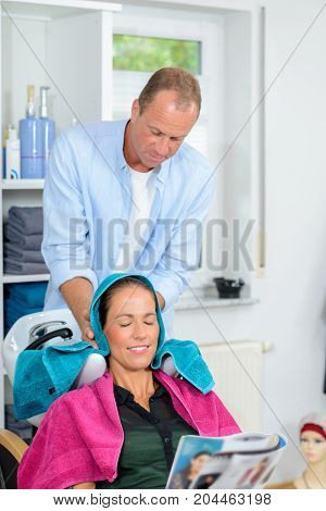 Hairdresser Washing Hair Of Woman