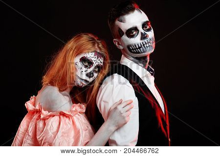 A classy couple, wearing skull make-up for. All souls day. Boy and girl in costumes of skeletons and sugar skull makeup