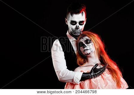 A classy couple, wearing skull make-up for. All souls day. Boy and girl in costumes of skeletons and sugar skull makeup