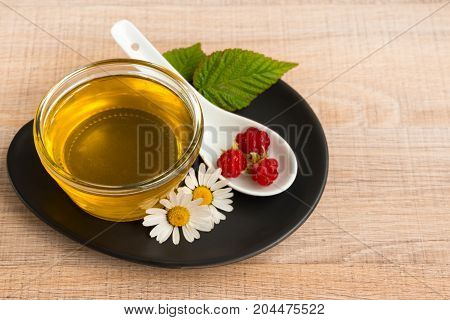 A Cup Of Honey On The Plate. The Honey In The Spoon Drops, Raspberry, Chamomile, Derevyanny Backgrou