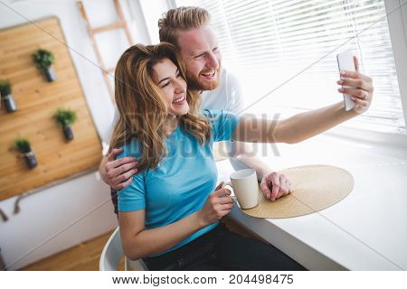 Romantic couple in love taking selfies and smiling at hime