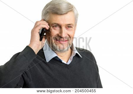 Portrait of mature man with phone. Close up of smiling elderly man speaking on mobile phone on white background.