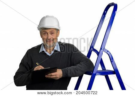 Mature engineer leaning on ladder. Senior builder supervisor with clipboard, ladder on white background.