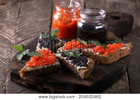Red And Black Caviar In Small Silver Spoon On A Wood Background With Black Bread ,food Concept