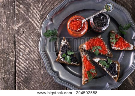 Red And Black Caviar In Small Silver Spoon On A Wood Background With Black Bread ,food Concept