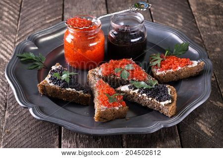 Red And Black Caviar In Small Silver Spoon On A Wood Background With Black Bread ,food Concept