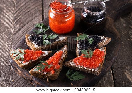 Red And Black Caviar In Small Silver Spoon On A Wood Background With Black Bread ,food Concept