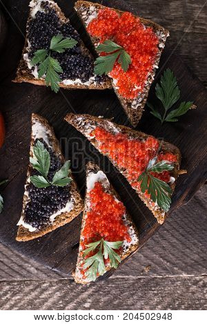Red And Black Caviar In Small Silver Spoon On A Wood Background With Black Bread ,food Concept