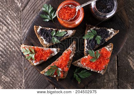 Red And Black Caviar In Small Silver Spoon On A Wood Background With Black Bread ,food Concept