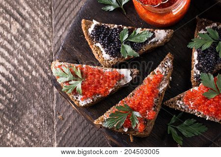 Red And Black Caviar In Small Silver Spoon On A Wood Background With Black Bread ,food Concept