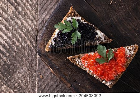 Red And Black Caviar In Small Silver Spoon On A Wood Background With Black Bread ,food Concept