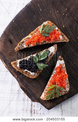 Red And Black Caviar In Small Silver Spoon On A Wood Background With Black Bread ,food Concept