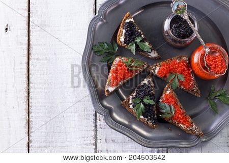 Red And Black Caviar In Small Silver Spoon On A Wood Background With Black Bread ,food Concept