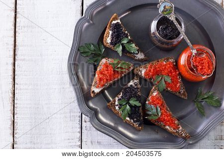 Red And Black Caviar In Small Silver Spoon On A Wood Background With Black Bread ,food Concept