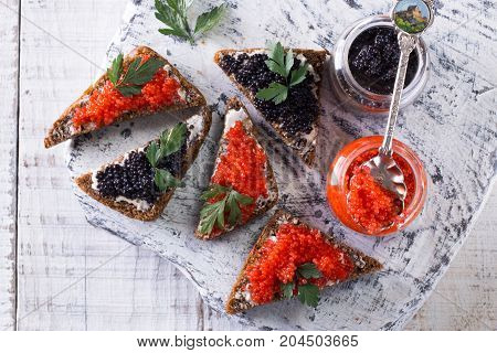 Red And Black Caviar In Small Silver Spoon On A Wood Background With Black Bread ,food Concept