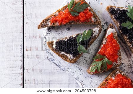 Red And Black Caviar In Small Silver Spoon On A Wood Background With Black Bread ,food Concept