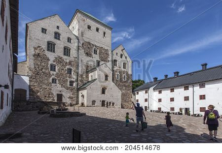 TURKU, FINLAND ON JUNE 30. Outdoor view of the Turku Medieval Castle from the 13th century on June 30, 2017 in Turku, Finland. Classical stone building. Unidentified people. Editorial use.