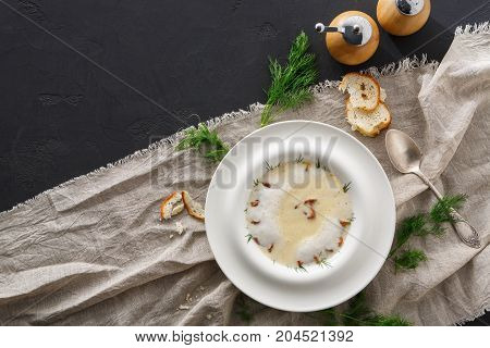 Delicious cream soup with honey fungus top view, copy space. Gourmet meal with mushrooms and crusty bread, restaurant serving
