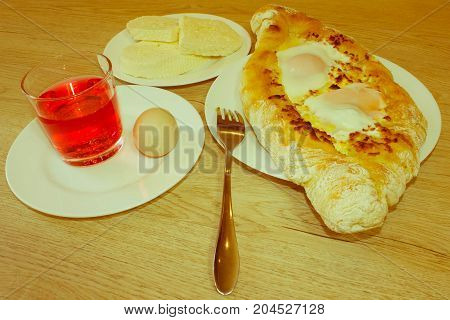 Adjarian khachapuri close-up. This traditional georgian dish contains brinsen cheese butter and row egg. Delicious homemade khachapuri in Adjarian - Retro color
