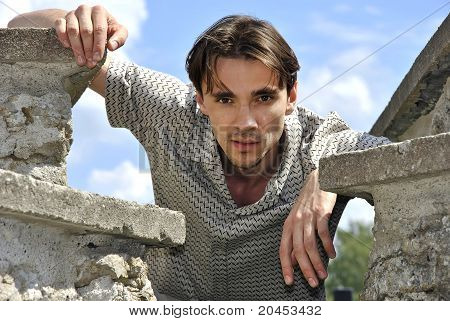 Jeune homme, se penchant sur les ruines