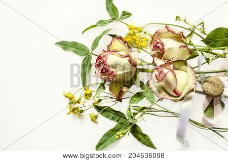 Bouquet of white with pink border roses wild flowers and clover leaves on white Bouquet of white with pink border roses wild flowers and clover leaves on white background
