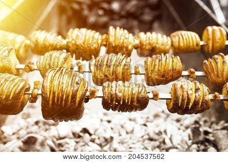 A Shish Kebab From Yellow Potatoes Put On A Skewer Is Fried On Blue Coals