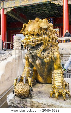 Beijing, China - Oct 30, 2016: Gilded bronze lion with right paw on globe at the Gate of Heavenly Purity, or Celestial Purity (Qianqingmen). Forbidden City (Gu Gong, Palace Museum).