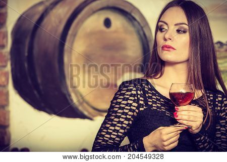 Woman Tasting Wine In Rural Cottage Interior