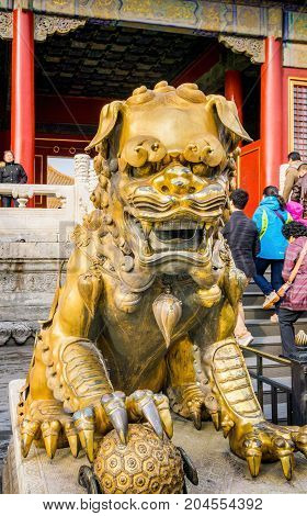 Beijing, China - Oct 30, 2016: Gilded bronze lion with right paw on globe at the Gate of Heavenly Purity, or Celestial Purity (Qianqingmen). Forbidden City (Gu Gong, Palace Museum).