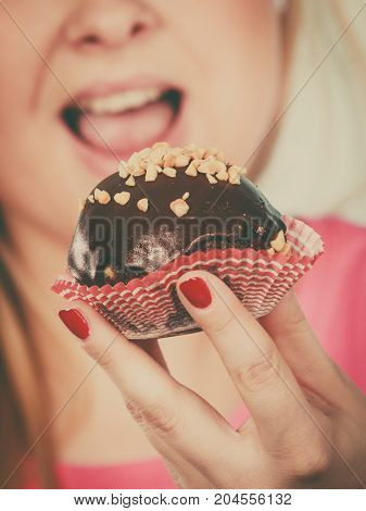Woman Holding Chocolate Cupcake About To Bite
