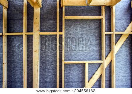Framework of the house wall of boards and timber a window a vapor barrier from the inside