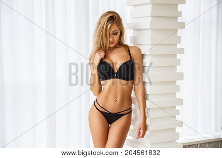 Beautiful girl blonde sexy bottom in lingerie posing in light apartments