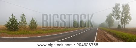 autumn rural landscape with road fog and forest. foggy path. autumn weather mist on way