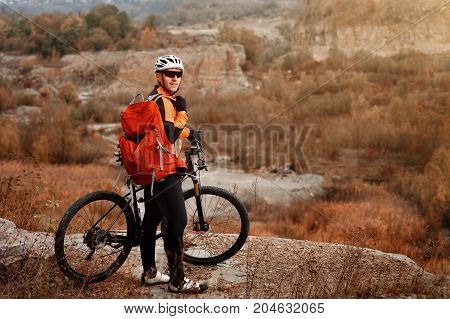 back view of a man with a bicycle and red backpack against the blue sky. cyclist rides a bicycle. Rear view people collection. backside view of person. blue sky background and mound.