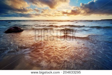 Seascape at sunset with rainy clous on the horizon