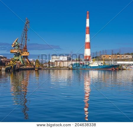 large striped power plant tube with reflection in water