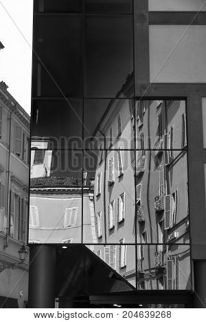 Parma (Emilia Romagna Italy): old and modern buildings in the Cesare Battisti square. Reflections. Black and white