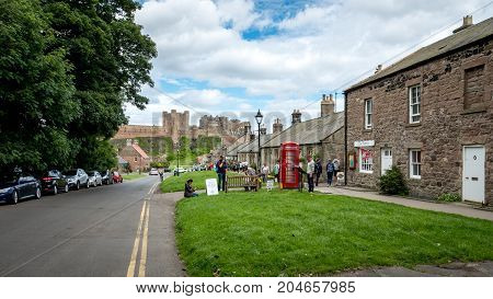 BAMBURGH UK - 2 JULY 2017: A view of the village of Bamburgh in North East England with the its famous landmark castle visible in the distance.