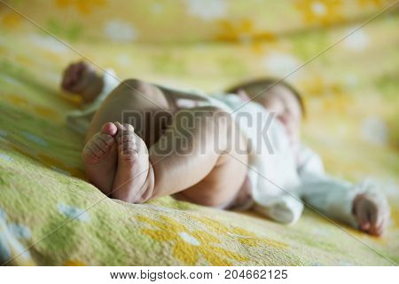Little baby girl legs. Indoors. Yellow, green