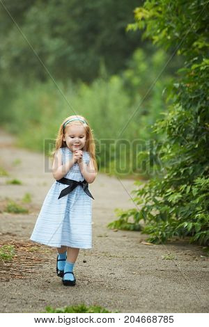 Small child. The girl walking. Green background