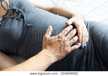 Pregnant girl. Motherhood. Father and mother touch