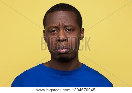 Offended African American guy on pop yellow background. Insult conversation. Upset black young male, sad news for man