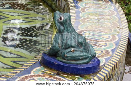 close up on a frog decoration of a foutain in the park maria luisa seville ( spains )