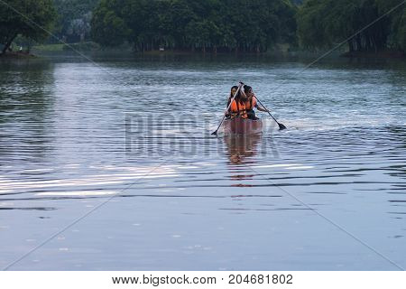 KUALA LUMPUR MALAYSIA - SEPTEMBER 17 2017: Smiling young woman kayaking on a lake. Happy young woman canoeing in a lake on a summer day.
