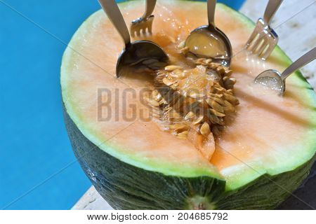 juicy fruit melon near pool. summer fruits and pool. fruits and sea. vacation time. spoon and melon. swimming pool. swimming pool and food. healthy fruits