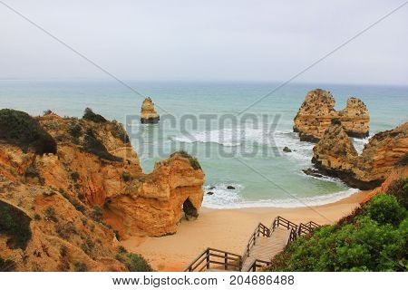 Praia do Camilo Beach in Lagos, Algarve Coast, Portugal. Famous travel destination for tourists in Europe with beautiful landscape views. Summer empty nature scene with no people around and copyspace